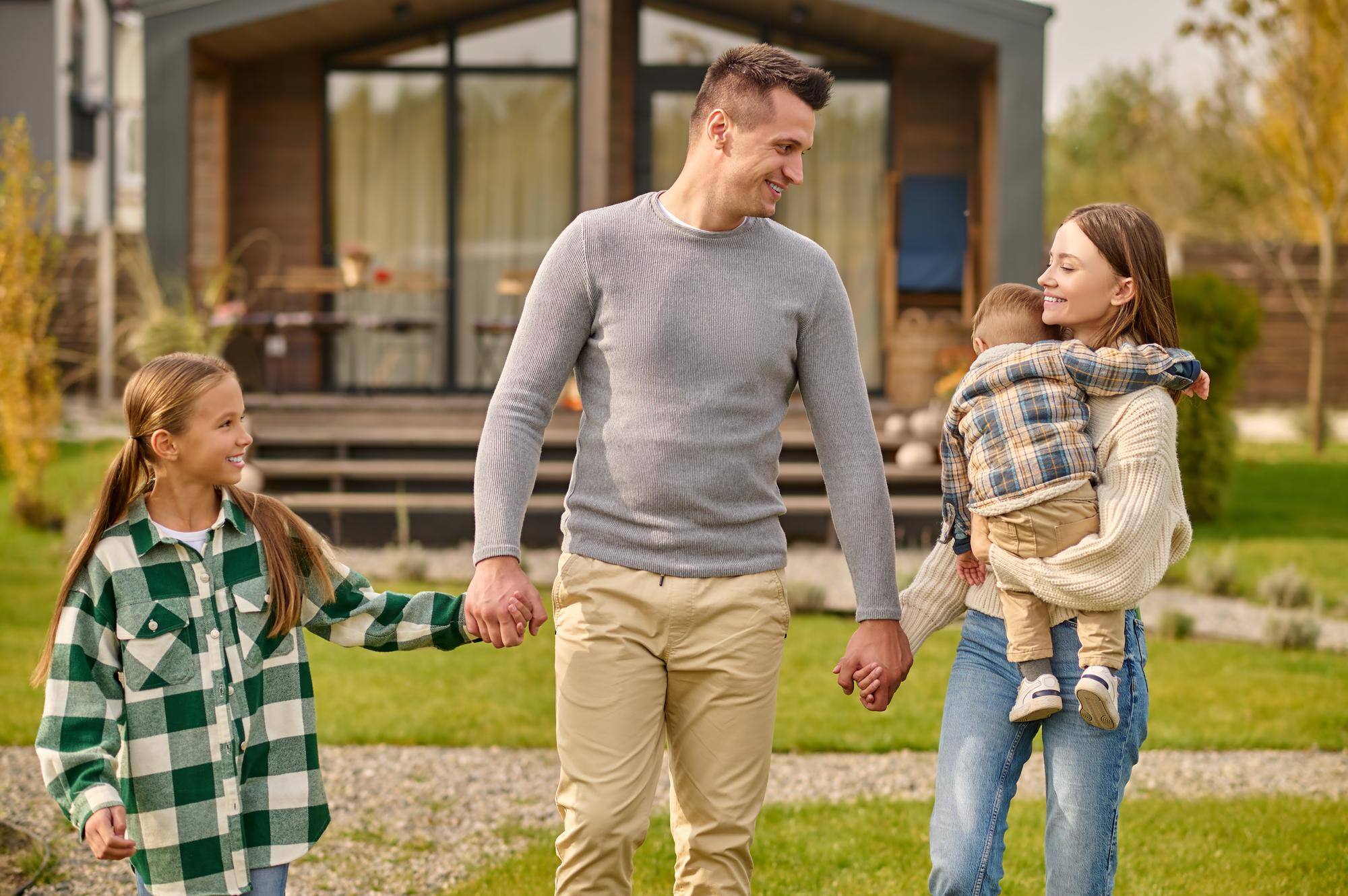 happy-family-holding-hands-walking-yard