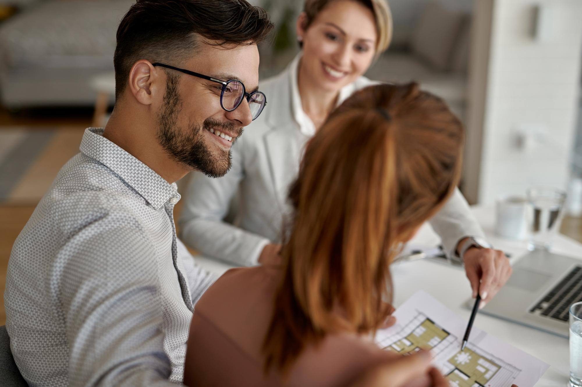 young-happy-couple-their-real-estate-agent-having-meeting-office-focus-is-man